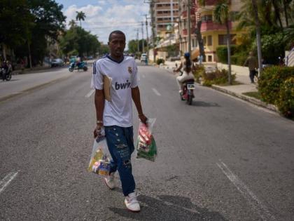 State-run bodega manager Roberto Roman carries bags of donated Mexican humanitarian assistance to be delivered to a family in Havana, Cuba, Thursday, February 19, 2026. 