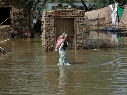 
A man carries usable belongings salvaged from his flood-hit home across a flooded area in Shikarpur district of Sindh province of Pakistan on August 31, 2022.
