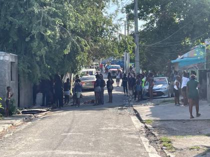 Residents and police personnel in Denham Town, Kingston on Saturday morning after a gun attack at a home, a toddler was killed and his brother and father were wounded.
