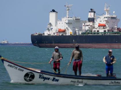 Fishermen pass an oil tanker in the Gulf of Venezuela off the shore of Punta Cardon, Venezuela, January 14, 2026. (AP Photo/Matias Delacroix, FIle)