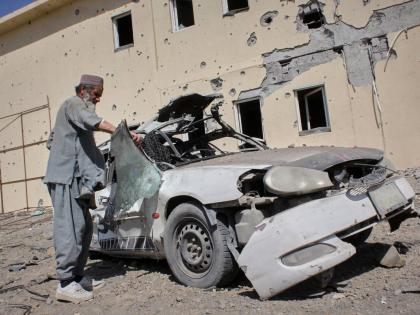 A man inspects a car damaged after a Pakistani strike on a refugee camp in Takhta Pul district, Kandahar province, Afghanistan.