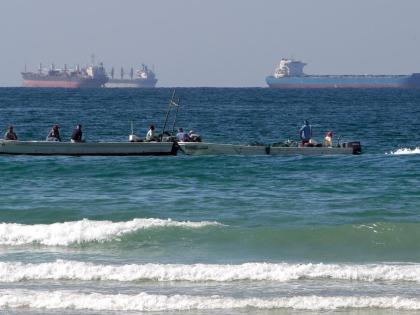 Fishermen working in front of oil tankers south of the Strait of Hormuz on January 19, 2012, offshore the town of Ras Al Khaimah in United Arab Emirates. 