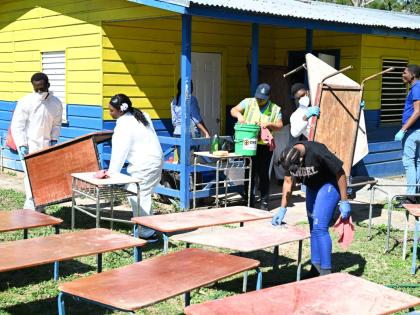 A joint team from the St James Police Division’s Community Safety and Security Branch (CSSB) and the Spot Valley High School Police Youth Club clears and cleans school furniture during ‘Operation Clean-Up’ at the infant department of Lethe Primary an