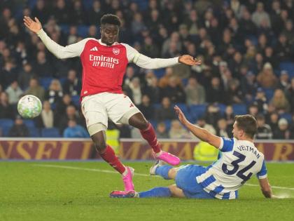 Brighton’s Joel Veltman (right) tackles Arsenal’s Bukayo Saka during the Premier League match in Brighton, England, yesterday.