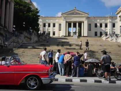 A car rides past students sitting outside the University of Havana during a protest over an energy crisis that has disrupted classes in Havana, Cuba, Monday, March 9, 2026. 
