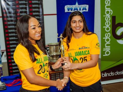 
Chanel Simpson (left ), head of private wealth at GraceKennedy Capital Management, presents last year’s All Jamaica Squash Championships title to Mehar Trehan.