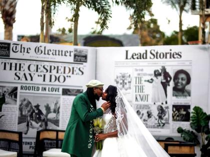 The couple share an enchanting kiss in front of an extravagant newspaper announcement marking their wedding.