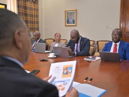 Prime Minister, Dr Andrew Holness (left), listens to Executive Director of the National Identification and Registration Authority, Dr Warren Vernon (right), during a recent meeting at the Office of the Prime Minister.