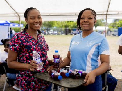 Sueann Ricketts (left), school nurse at St Catherine High School, poses for a photo with student Toronary Walker as they distribute refreshments during the school’s Sports Day activities on Thursday, March 12. St Catherine High School was one of the late