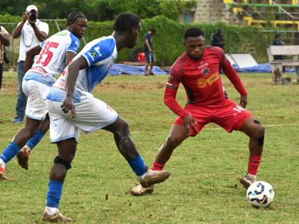 Montego Bay United’s Okeemo Jones (right) tries to intercept a pass from Dunbeholden FC’s Odae Samuels during their Jamaica Premier League football game at Jarrett Park in Montego Bay yesterday.