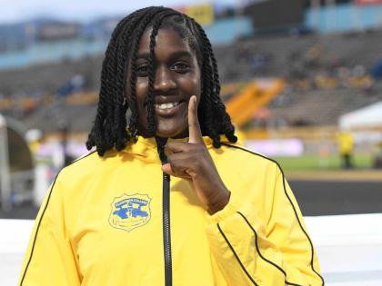 Clarendon College’s Jamelia Young is all smiles after successfully defending her Class 2 shot put title at the ISSA/GraceKennedy Boys and Girls’ Athletics Championships inside the National Stadium yesterday.