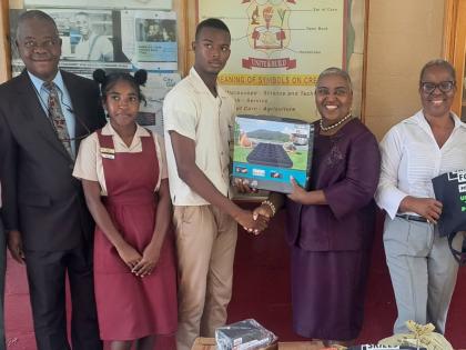  Donna Parchment-Brown hands over an inflatable mattress to Newell High School head boy Gary Blake on Friday. Also in the picture (from left) are Dr Adeniyini Bamedele, foundation board member; head girl Kimberley Thompson, and Principal Audrey Ellington. 