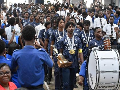 Jamaica College athletes march into the auditorium for Monday’s celebrations following their victory in the ISSA/GraceKennedy Boys’ Championships on the weekend.