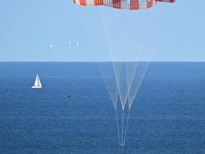 In this photo provided by NASA, NASA’s Orion capsule descends under its main parachutes over the Pacific Ocean off the coast of California, following the Artemis II mission on Friday, April 10, 2026.
