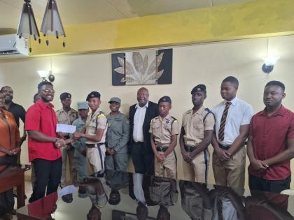 Odaine Thomas, junior warden of Friendly Lodge 383, presents a cheque on behalf of the Freemason Association of Jamaica to Lance Corporal Andrew Cammock of the Cornwall College Cadet Unit. Sharing in the occasion are Lecia Allen (left), vice-principal of C