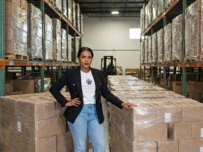 Kith‑Ann Excell, organiser of the Comfort and Care Relief Drive, stands alongside donated relief supplies at a Florida warehouse.