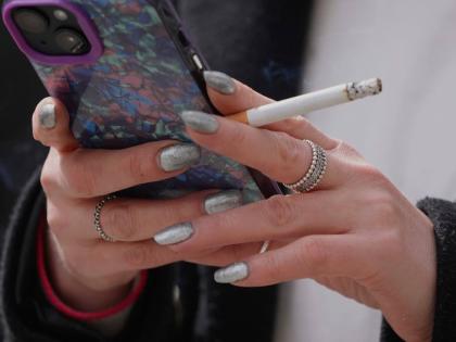 A woman smokes on a street in London on April 16, 2024. (AP Photo/Kin Cheung, File)