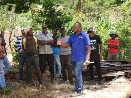 Gerald Bryan (right), head of the Spices Unit at JACRA, delivers a presentation to coffee farmers during the High Mountain Coffee Revitalisation Training, highlighting best agronomic practices to improve productivity and strengthen Jamaica’s coffee indus