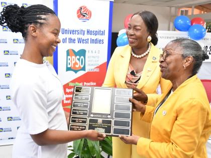 Sashara Rust (left), operating theatre nurse, Tony Thwaites Wing Operating Theatre, The University Hospital of the West Indies (UHWI); accepts her Nurse of Excellence award from Helena Thomson (right), senior director of nursing at the UHWI; and Delories J