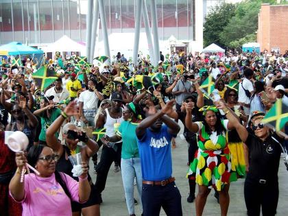 Jamaicans and friends of Jamaica wave the Jamaican flag during JAMAICA Fest 2025, hosted by the Embassy of Jamaica at Veterans Plaza in downtown Silver Spring, Maryland.