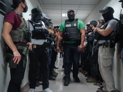 Masked federal agents wait outside an immigration courtroom, July 8, 2025, in New York.