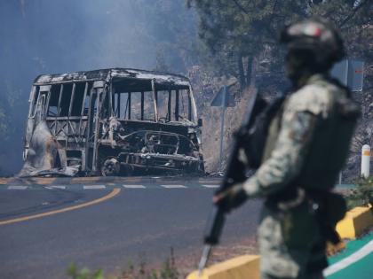 A soldier stands guard by a charred vehicle after it was set on fire in Cointzio, Michoacán state, Mexico, February 22, following the death of the leader of the Jalisco New Generation Cartel, Nemesio Oseguera, also known as ‘El Mencho’.