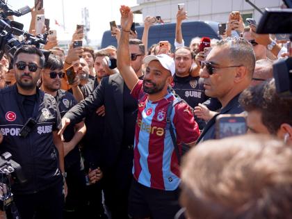 Egypt’s Mohamed Salah wearing his new Trabzonspor team jersey gestures to supporters as he arrives at the airport in Istanbul, Turkey, Wednesday, August 5, 2026. 