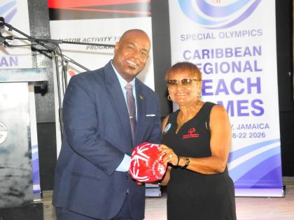 Deputy Mayor of Montego Bay Dwight Crawford (left) receives an official football for the inaugural Special Olympics Caribbean Beach Games from Lorna Bell, executive director of the Special Olympics Caribbean, during Tuesday’s official launch of the Games