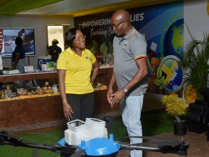 Alecia Clarke, business solutions manager at JN Bank, listens with interest as Rural Agricultural Development Authority (RADA) Chief Executive Officer Garnet Edmondson outlines the capabilities of the Samson One drone, developed by Jamaican technology comp