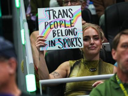 A person holds a “trans people belong in sports” sign during the first half of a WNBA basketball game between the Seattle Storm and the Indiana Fever, Tuesday, July 28, in Seattle. 