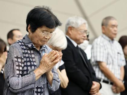 People observe a minute of silence during a ceremony to mark the 81st anniversary of the US atomic bombing at the Peace Park in Nagasaki, southern Japan.