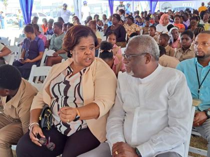 Dr Michelle Pinnock, the regional director for the Ministry of Education, Skills, Youth, and Information’s Region Four office, speaks with St James’ Custos, Bishop Conrad Pitkin, during a back-to-school financial aid programme put on by the Excelerate 