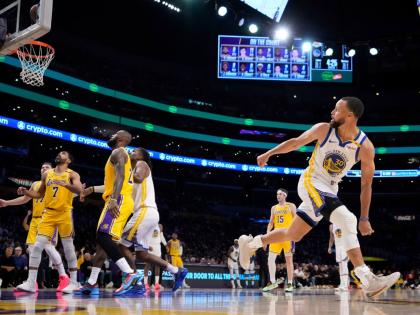 FILE - Golden State Warriors guard Stephen Curry, right, watches his shot go in during the first half of an NBA basketball game against the Los Angeles Lakers in Los Angeles., April 3, 2025. (AP Photo/Mark J. Terrill, File)