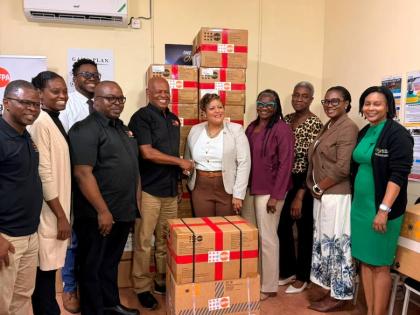Harold Robinson (centre), director and representative, United Nations Population Fund (UNFPA) Sub-Regional Office for the Caribbean, formally hands over UNFPA’s donation of reproductive health and midwifery kits to Kristal Lee, Minister of State in the M