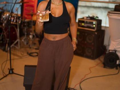 Trishana Williams, financial service representative, holds her Appleton Estate Spanish Sherry cocktail in hand, dressed in casual chocolate brown slacks, a matching head scarf, and a black halter.
