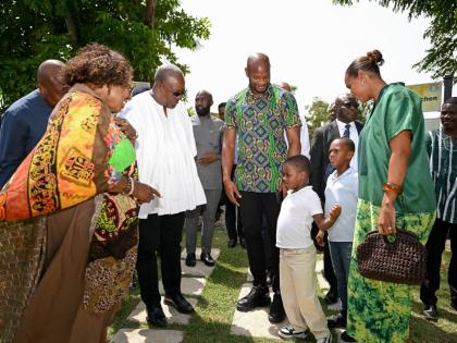 Minister of Culture, Gender, Entertainment and Sport, Olivia Grange (left), and President of the Republic of Ghana, John Dramani Mahama (second left), meet Jamaican sprint legend, Asafa Powell (third left), and members of his family during a visit to Sevil