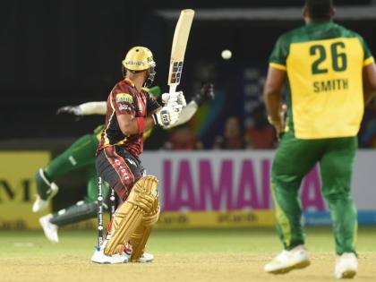 Trinbago Knight Riders' Nicholas Pooran (centre) is given a lifeline after Jamaica Kingsmen wicketkeeper, Shayan Jahangir (partially hidden) spills a chance during a Republic Bank Caribbean Premier League game at Sabina Park tonight. Looking on is Kingsmen