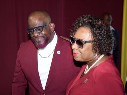 
Paul Francis, brother of Stephen Francis (left), and Olivia ‘Babsy’ Grange, minister of culture, gender, entertainment and sport, share a moment at the thanksgiving service for the late coach at the National Indoor Sports Centre yesterday.