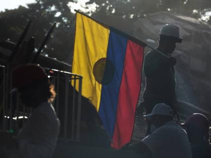 A firefighter working on rescue efforts holds a Colombian flag amid the rubble three days after an earthquake struck Cali, Colombia, August 13.