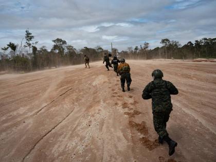 Peruvian Navy soldiers run as they get off a helicopter during an operation to combat illegal mining in the Tambopata National Reserve in Puerto Maldonado, Peru, on August 11.