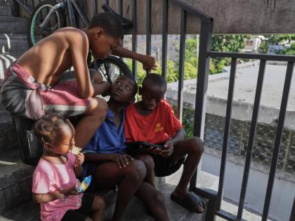 Children watch a movie on a mobile device at a shelter for families displaced by gang violence in Port-au-Prince, Haiti, Wednesday.