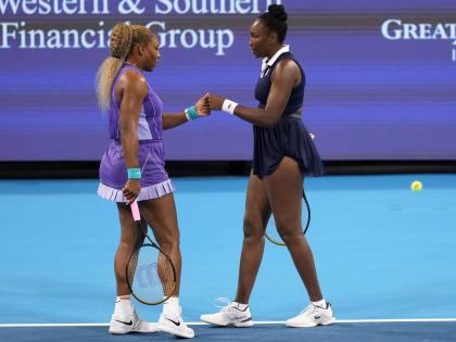 Serena Williams (left) first bumps Venus Williams (right), both of the United States, during a women's doubles match against Marta Kostyuk of Ukraine, and Peyton Stearns of the United States, at the Cincinnati Open tennis tournament on Monday, August 17, i