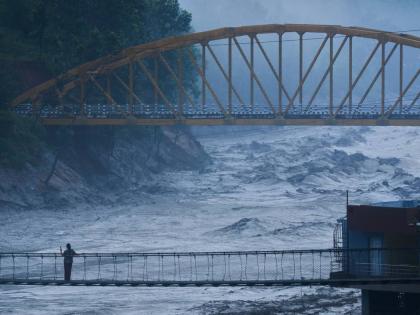 A resident looks at the swollen Trishuli river in Galchhi, Dhading District, Nepal.
