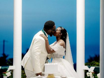 The groom leans in to give his bride a sweet kiss.