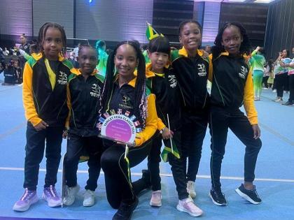 Sherri-Lee Smith, gymnastic coach at First Dance, Montego Bay (centre), is flanked by from left; Alexia Allen, MaCherie Wynter, Kaelei Palmer, and Jenneilia Grant walk the stage to represent Jamaica at the opening ceremony of the Yamilet Pena Gymnastics Cl
