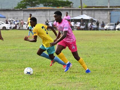 
Rusea’s High School’s Mikkel Hason (right) dribbles while being closely attended by Little London’s Damani Smith during their ISSA daCosta Cup clash at the Little London playfield yesterday.