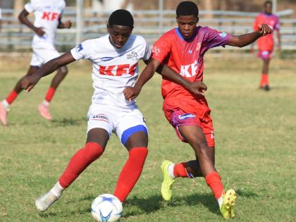 Camperdown High School’s Oneil Patrick (left) and Bridgeport’s Matthew McLarty compete for the ball during their Manning Cup football clash at the Dunbeholden playing field yesterday.