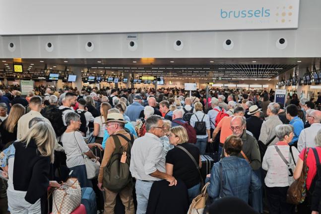 People stand in a line to check in after a cyberattack caused delays at Brussels International Airport in Zaventem, Belgium, Saturday, September 20, 2025. (AP Photo/Harry Nakos)