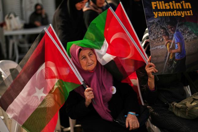 A woman waves Turkish and Palestinian flags during a sit-in gathering against the interception of the Gaza-bound Sumud flotilla by Israeli navy forces, in Istanbul.
