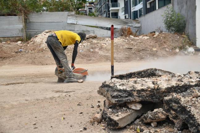 In this August photo, a worker is seen cutting the surface of a road on Wellington Drive where NWA was laying pipelines.
